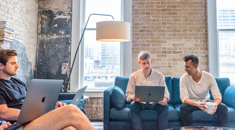 Young men in meeting with laptops