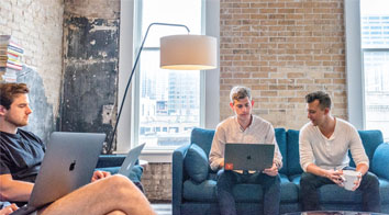 Young men in meeting with laptops