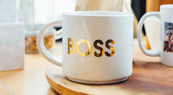 white mug with gold foil BOSS on wooden board